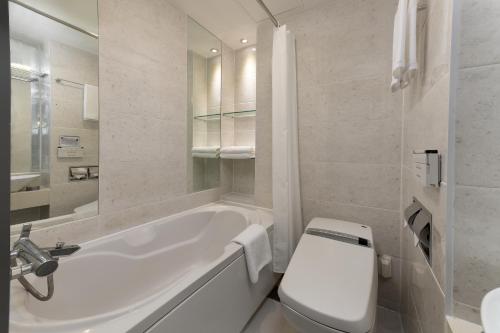 a bathroom with a white tub and a toilet at Travelodge Myeongdong Namsan in Seoul