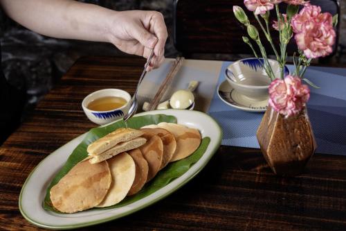 a plate of food with a plate of bread on a table at Gateway Inn Puluong in Pu Luong