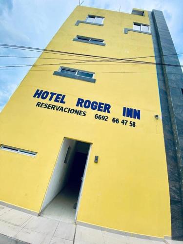 un edificio amarillo con una puerta con una posada de robos en hotel roger Inn mazatlan, en Mazatlán