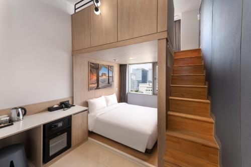 a small room with a bed and a staircase at Travelodge Myeongdong Namsan in Seoul