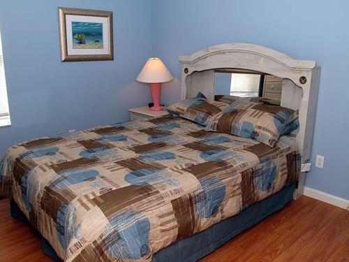 een slaapkamer met een groot bed met een blauwe muur bij Fan Palm Villa 8208 in Kissimmee