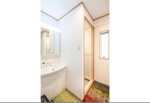 a bathroom with a sink and a mirror at Travel Palace Miyuki in Kawaguchi