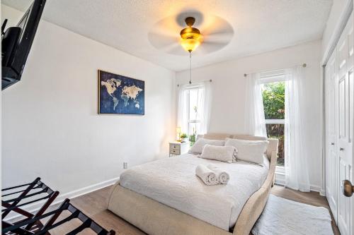 1 dormitorio con 1 cama y ventilador de techo en Gorgeous open concept 4 BR with heated pool and lounge area, en Fort Lauderdale