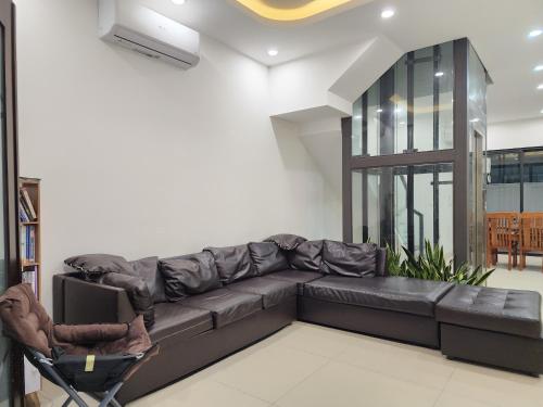 a living room with a black leather couch at Timi Homestay Near the Wave Park Ocean Park 2 in Hòa Bình
