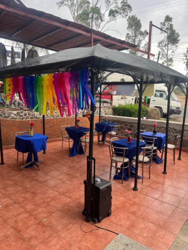 a group of tables and chairs under a umbrella at Hotel La Loma in Huasca de Ocampo