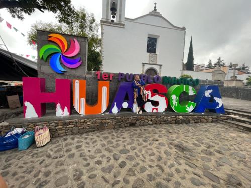 a sign that says hula in front of a church at Hotel La Loma in Huasca de Ocampo