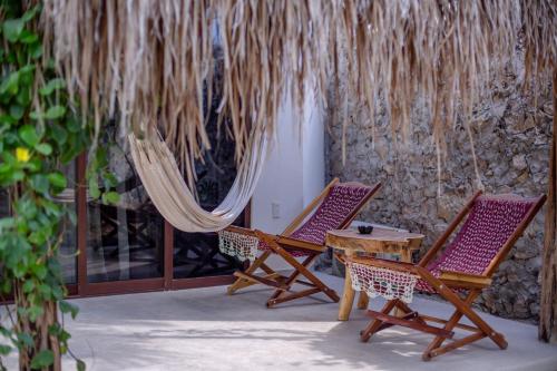 dwa krzesła i stół na patio w obiekcie Casa Cactus Buenavista w mieście Bacalar