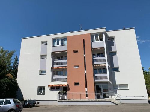 um edifício alto com um carro estacionado em frente em Appartement cosy 29 m2 à 5 min Basel parking gratuit em Saint-Louis
