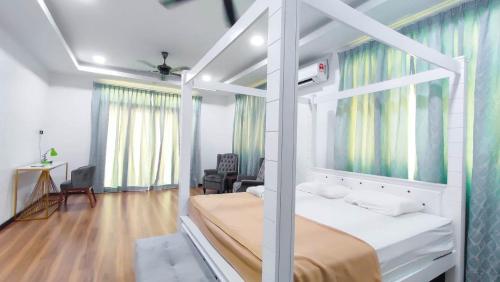 una camera con un letto bianco a baldacchino di Villa TMA a Kuala Terengganu