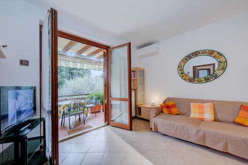 - un salon avec un canapé et une porte coulissante en verre dans l'établissement Verde Giada with pool - Happy Rentals, à Toscolano Maderno