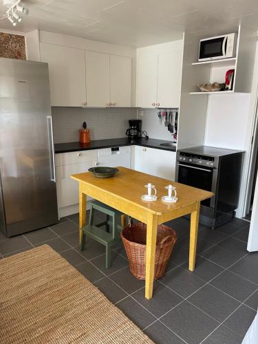eine Küche mit einem Holztisch und einem Kühlschrank in der Unterkunft Pia’s Country House in Båstad
