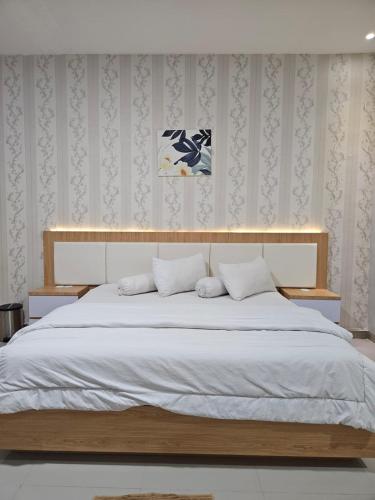 a bedroom with a large bed with white sheets at LOSMEN 88 in Ratodena
