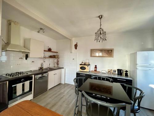 a kitchen with a stove and a table with chairs at Magnifique appartement devant la plage in Propriano