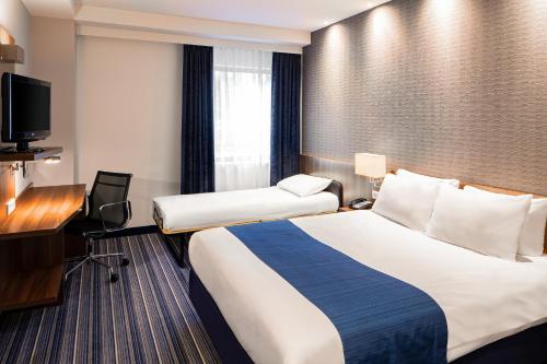 a hotel room with two beds and a desk at Holiday Inn Express Amsterdam - South, an IHG Hotel in Amsterdam