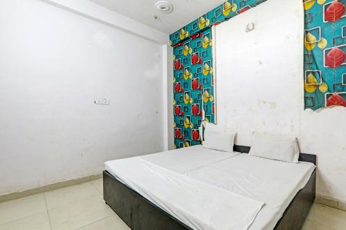 a room with a bed and a colorful wall at OYO Hotel Surya Palace in Kushinagar