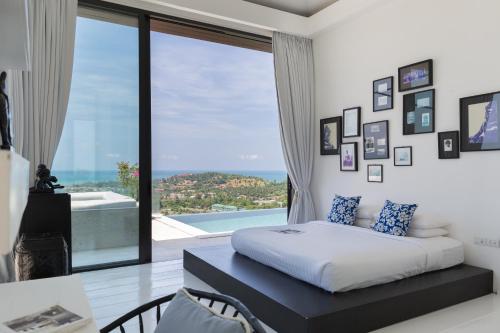 1 dormitorio con cama y ventana grande en Villa Belle, en Choeng Mon Beach