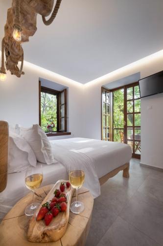 a bedroom with a bed and two glasses of wine at Palios Stathmos in Miléai
