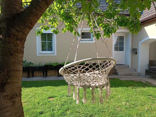 Eine Korbschaukel hängt von einem Baum im Hof in der Unterkunft Edelsbacher Ferienwohnung 