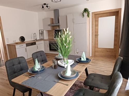 ein Esszimmer mit einem Tisch und Stühlen sowie eine Küche in der Unterkunft Edelsbacher Ferienwohnung 