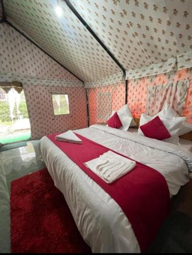 una camera con due letti con lenzuola rosse e bianche di Parvati Camp's Kasol a Kasol