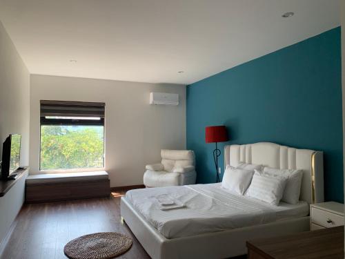 a bedroom with a white bed and a blue wall at SEA 1 Villa 5BR in Quy Nhon