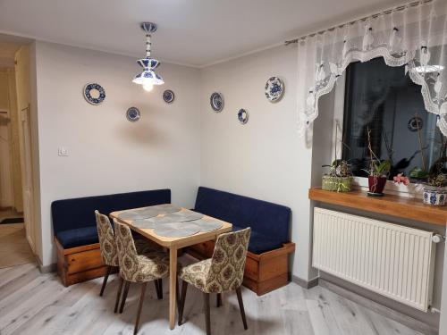 a dining room with a table and chairs at Apartamenty Łąkowa Piecki in Piecki