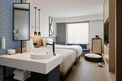 a hotel room with a large bed and a sink at Fairfield by Marriott Hiroshima Sera in Sera