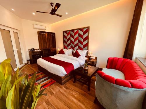 ein Hotelzimmer mit einem Bett und zwei Stühlen in der Unterkunft Sambha Lodge in Kota