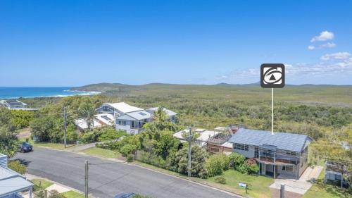 an aerial view of a residential neighbourhood with a sign at Jinalong in Yamba