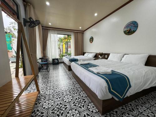 a bedroom with two beds and a balcony at Azalea Tam Coc Ninh Bình in Ninh Binh