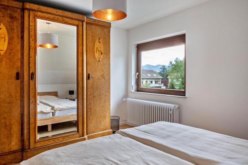 - une chambre avec un miroir, un lit et une fenêtre dans l'établissement Ferienwohnung Kühn, à Kirchzarten