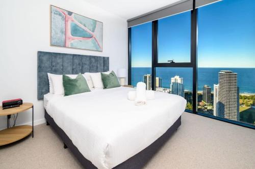 a bedroom with a large white bed and large windows at Cloud Nine Retreat - Luxe 44th Fl Apartment in Gold Coast