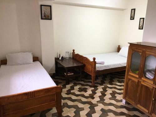 pokój z dwoma łóżkami i stołem w obiekcie Mountaintop Guest House w mieście Bhurtuk