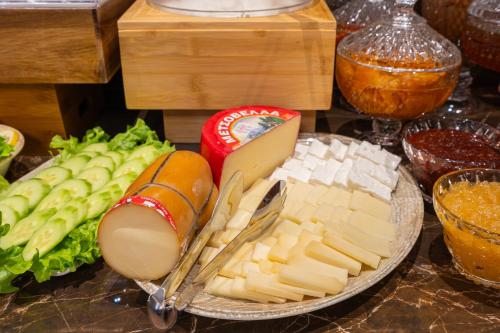 a plate of cheese and vegetables on a table at FLOARA DI MUNTE Forest Luxury Suites in Metsovo