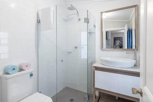 a bathroom with a shower and a toilet and a sink at Modern Heritage Home - Stunning Bridge Views in Sydney