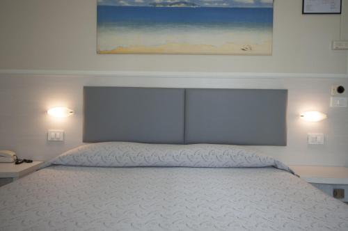 a bedroom with a bed with two lights on at Hotel Boccaccio-free parking- in Milano Marittima