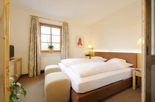 a hotel room with two beds and a window at Landhaus Tanner in Waging am See