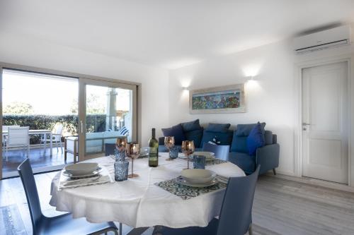 uma sala de jantar com uma mesa e um sofá azul em Sardinia Gold Luxury Apartment em Palau