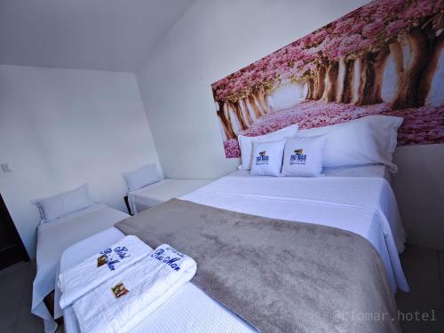 a bedroom with two beds with towels on them at Hotel e Restaurante Rio Mar in Valença
