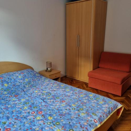 um quarto com uma cama, uma cadeira e um armário em Apartman Surić em Novi Vinodolski