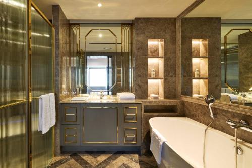 a bathroom with a tub and a large mirror at Imperial Palace Seoul Gangnam in Seoul