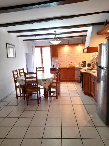 une cuisine avec une table et des chaises dans l'établissement L'ase et la tuca, à Bessan