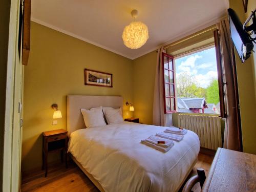 a bedroom with a large bed and a window at HOTEL DE L'ABBAYE DE LONGPONT in Longpont