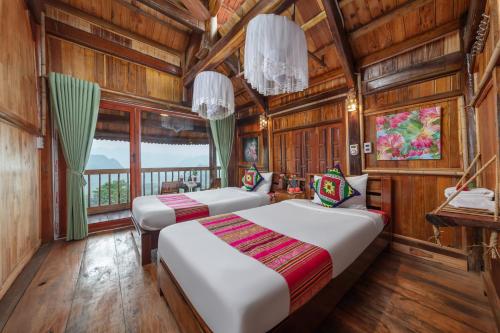two beds in a room with wooden walls at Gateway inn Puluong in Thanh Hóa