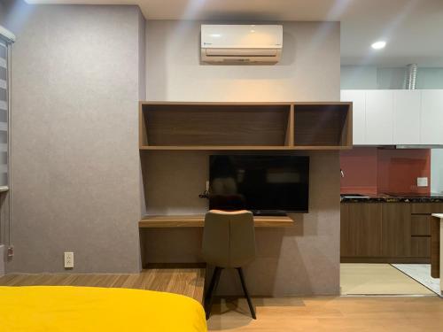 ein Schlafzimmer mit einem Schreibtisch und einem TV in einem Zimmer in der Unterkunft LUCY HOTEL & APARTMENT D1 in Ho-Chi-Minh-Stadt