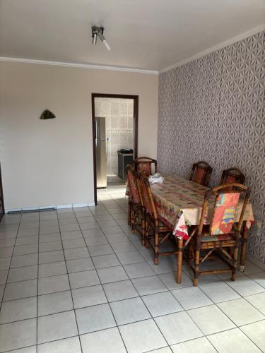 Un comedor con mesa y sillas en Apartamento beira-mar em Mongaguá, en Mongaguá