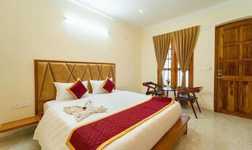Schlafzimmer mit einem Bett, einem Tisch und einem Fenster in der Unterkunft FabHotel Prime AR Phalazzo Resort in Puducherry
