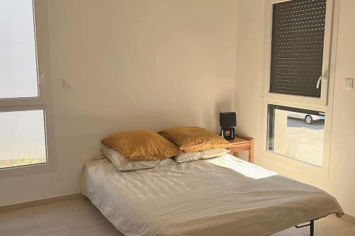 een bed in een kamer met twee kussens erop bij Maison neuf centre ville in Metz