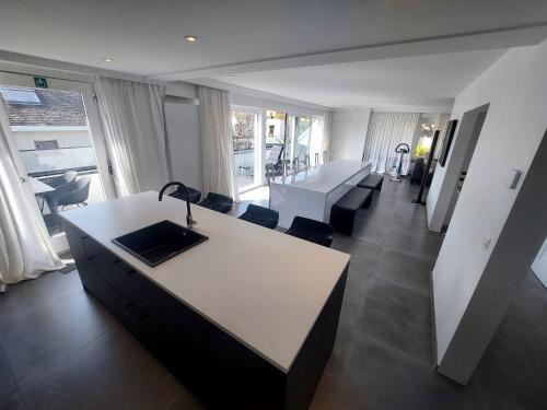 een woonkamer met een bureau en een tafel en stoelen bij The White Villa in Blankenberge