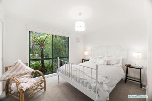 een witte slaapkamer met een bed en een raam bij Villa de Mer at Phillip Island in Cowes